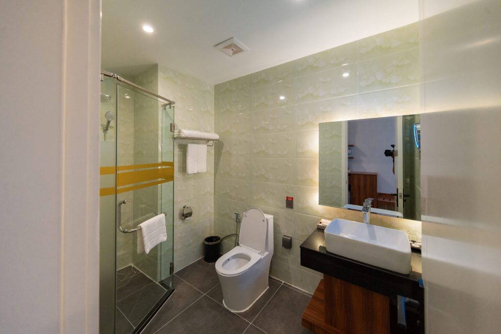 Royal Legend Room bathroom: modern toilet and separate glass shower at Legend Hotel & Resort Sihanoukville, Cambodia.