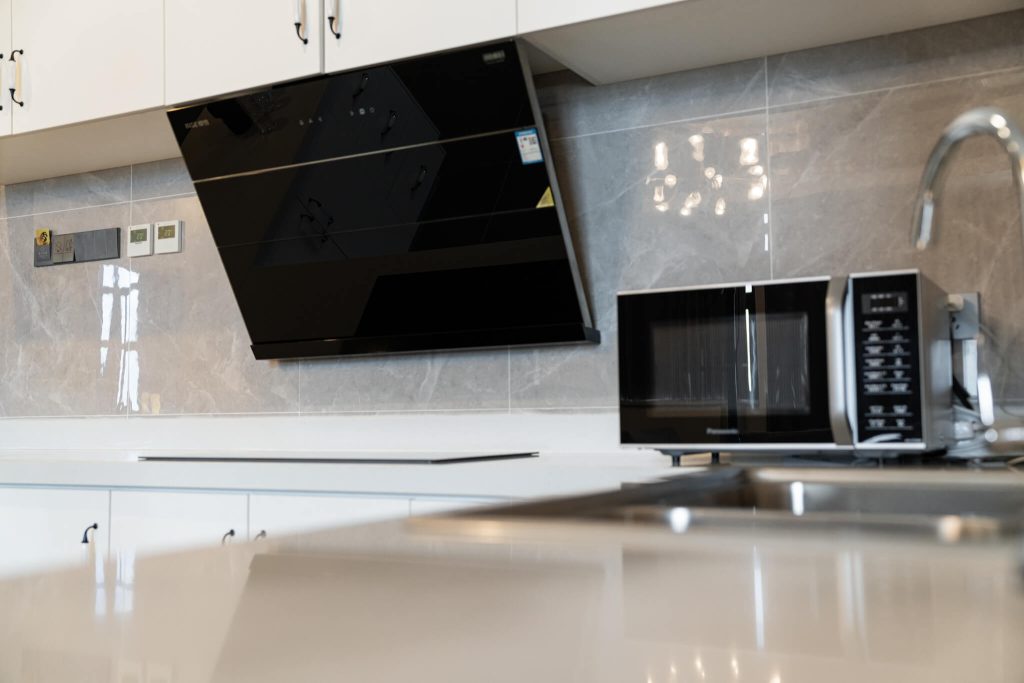 In-room kitchen amenities at Royal Legend, Legend Hotel & Resort Sihanoukville: television, microwave, and sleek countertops.
