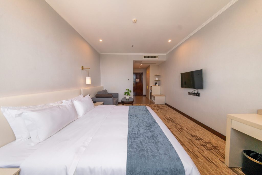 Spacious Deluxe King bedroom at Legend Hotel & Resort Sihanoukville, Cambodia, featuring a comfortable king-size bed in vertical spacing.