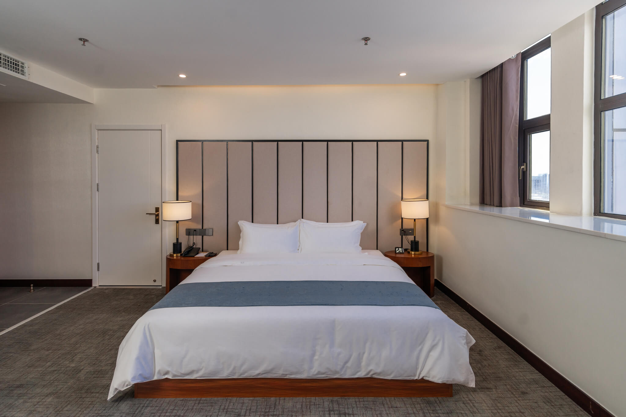 Cozy and spacious Executive Suite hotel room with king bed and city view of Sihanoukville, Cambodia.
