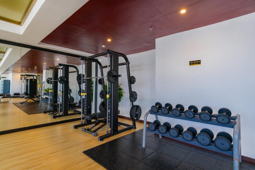 Sihanoukville Gym at Legend Hotel & Resort with city and sea views. Weightlifting equipment including dumbbells and machines.