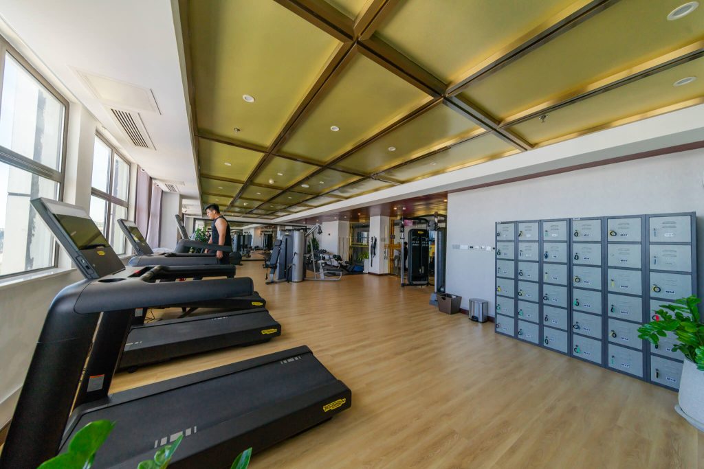 Fitness center at Legend Hotel Sihanoukville: modern gym with multiple treadmills and convenient locker facilities.